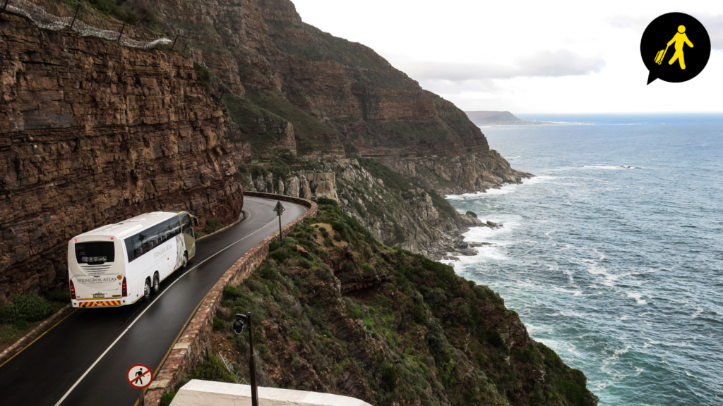 driving along the side of a cliff next to the ocean.
