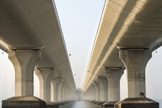 The underside of two adjacent bridges spanning into the distance