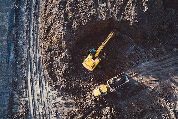 A yellow digger in a quarry, viewed from above