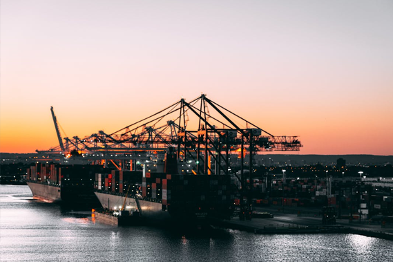 A sunset view of a large container ship being loaded
