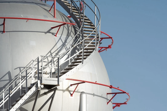 A close-up of a gas storage tank, with steps spiralling up the side